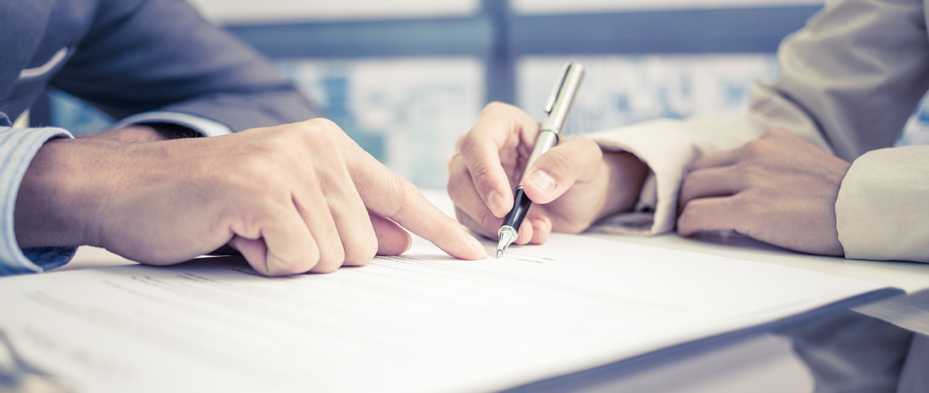 Two people collaboratively signing a document