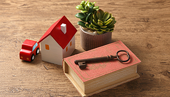 A wooden table displaying a book, a toy car, and a key